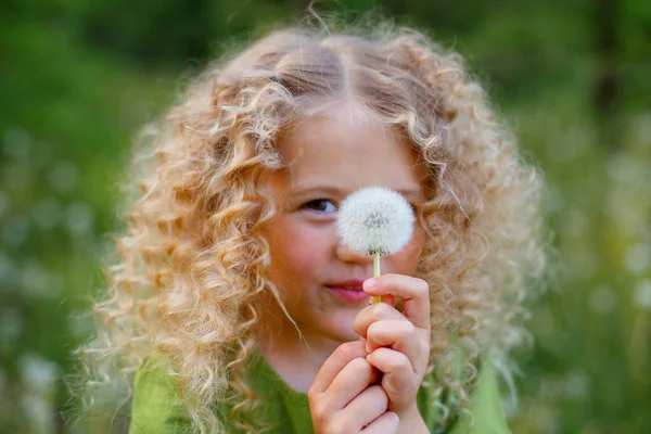 Pequena Loira Encaracolado Menina Vestido Verde Soprando Segurar Dente Leão — Fotografia de Stock