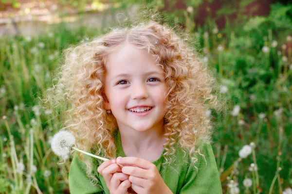 Маленька Кучерява Блондинка Зеленій Сукні Дме Кульбабу Парковій Посмішці — стокове фото