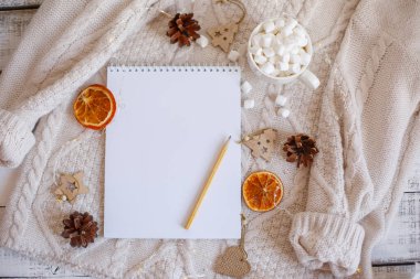 Boş Noel Baba listesi ve ahşap arka planda Noel süslemesi olan düz bir kompozisyon.