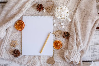 Boş Noel Baba listesi ve ahşap arka planda Noel süslemesi olan düz bir kompozisyon.