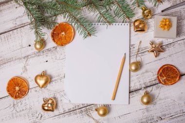 Boş Noel Baba listesi ve ahşap arka planda Noel süslemesi olan düz bir kompozisyon.