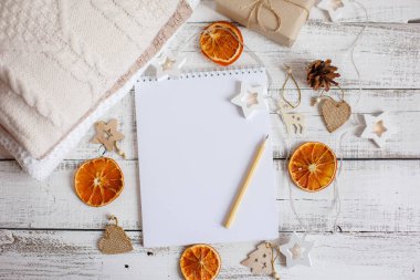 Boş Noel Baba listesi ve ahşap arka planda Noel süslemesi olan düz bir kompozisyon.