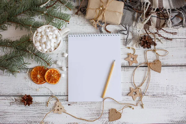 Boş Noel Baba listesi ve ahşap arka planda Noel süslemesi olan düz bir kompozisyon.