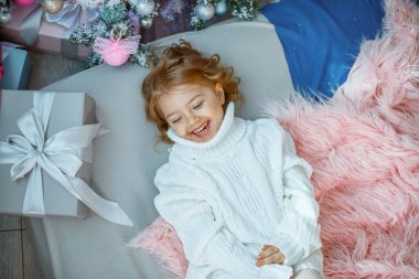 Noel ağacının yanında küçük bir kız yatağında yatıyor.