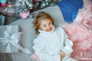 Noel ağacının yanında küçük bir kız yatağında yatıyor.