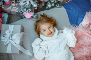 Noel ağacının yanında küçük bir kız yatağında yatıyor.
