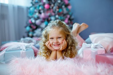 Noel ağacının yanında küçük bir kız yatağında yatıyor.