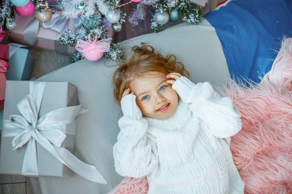 Una Bambina Vicino All Albero Natale Sdraiata Sul Letto — Foto Stock