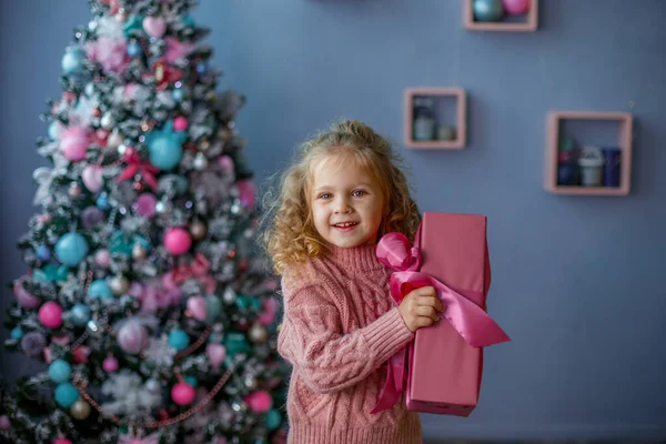 Una Bambina Vicino All Albero Natale Tiene Una Palla Natale — Foto Stock