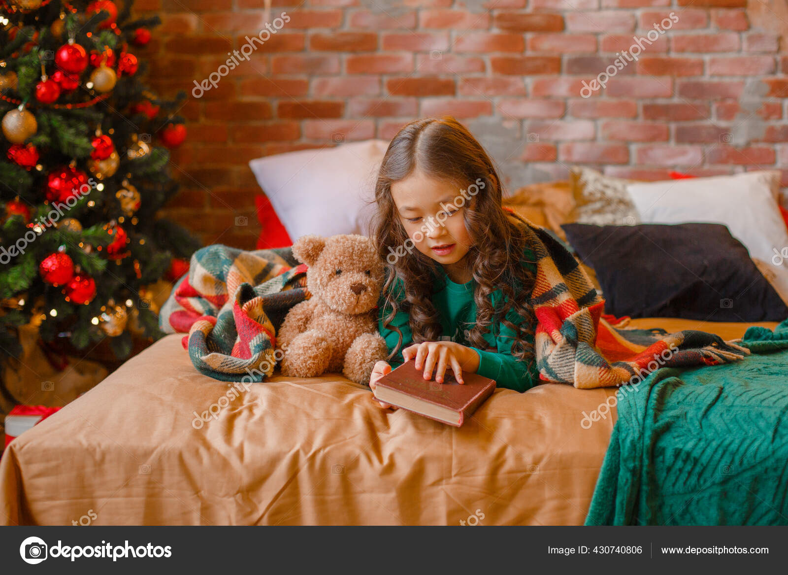 little-asian-girl-pajamas-bedroom-lying-bed-christmas-tree-reading