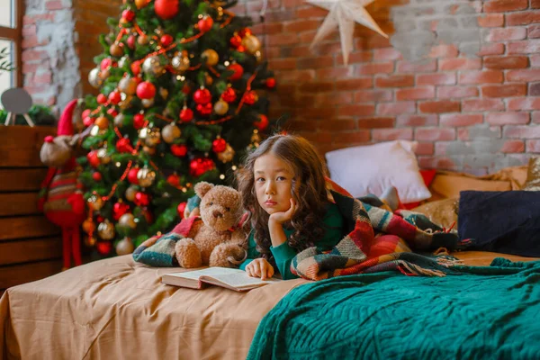 Little Asian Girl Pajamas Bedroom Lying Bed Christmas Tree Reading — Stock Photo, Image