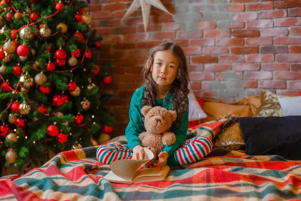 Little Asian Girl Pajamas Bedroom Lying Bed Christmas Tree Reading — Stock Photo, Image