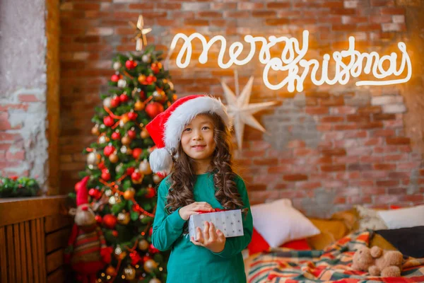 Little Asian Girl Pajamas Christmas Tree Holds Gift Christmas New — Stock Photo, Image