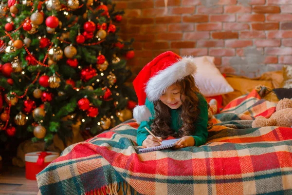 Little Asian Girl Pajamas Christmas Tree Writes Letter Santa Claus — Stock Photo, Image