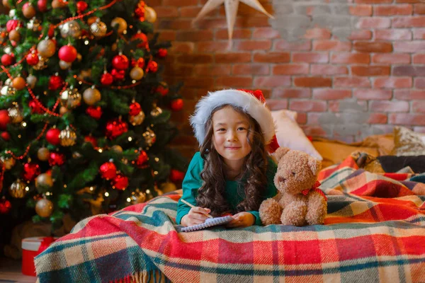 Little Asian Girl Pajamas Christmas Tree Writes Letter Santa Claus — Stock Photo, Image