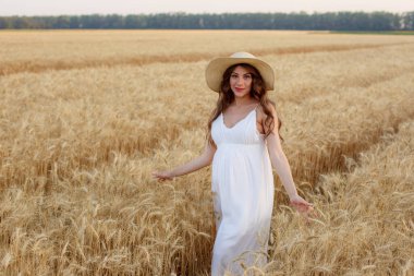 pregnant woman in a straw hat in a field of wheat clipart