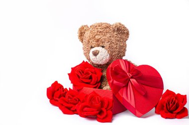 Kırmızı güller ve beyaz arka planda bir hediye.