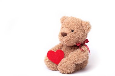 Beyaz arka planda kalbi tutan oyuncak ayı.
