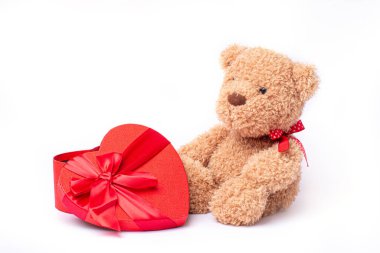 Kalp şeklinde sevgililer günü kutusuna sahip oyuncak ayı beyaz arka planda izole edilmiş.