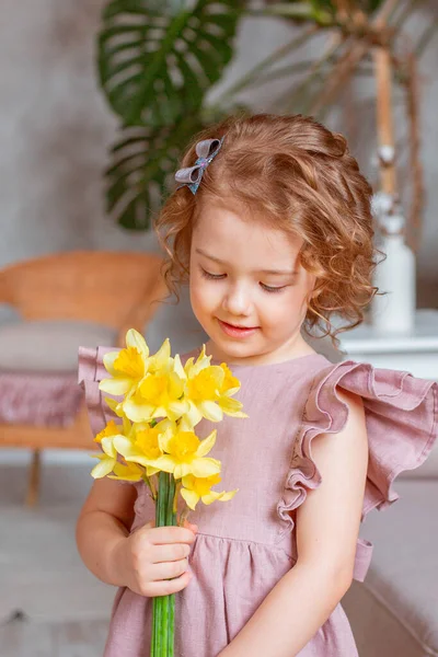 Klein Schattig Meisje Houdt Een Boeket Van Narcissen Thuis — Stockfoto