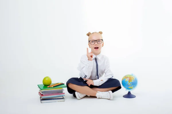 Una Piccola Studentessa Uniforme Scolastica Seduta Isolata Uno Sfondo Bianco — Foto Stock