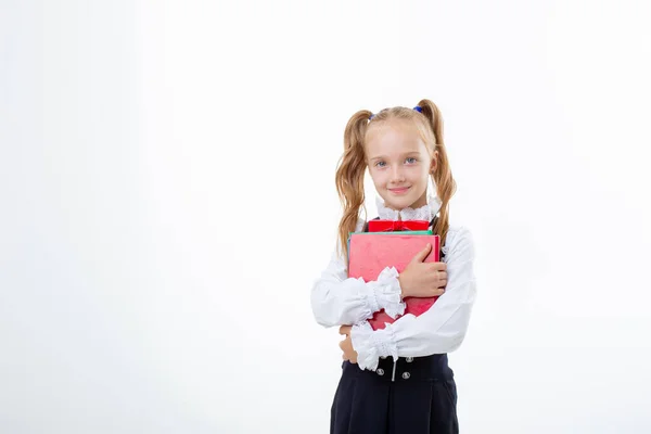 Ein Kleines Schulmädchen Schuluniform Hält Ein Buch Isoliert Auf Weißem lizenzfreie Stockbilder