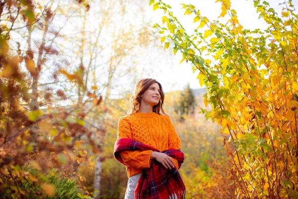 Młoda Kobieta Pomarańczowym Swetrze Owija Się Szalik Jesiennym Parku — Zdjęcie stockowe