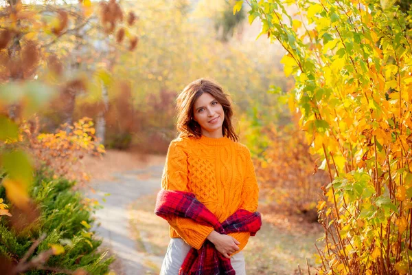 Młoda Kobieta Pomarańczowym Swetrze Owija Się Szalik Jesiennym Parku — Zdjęcie stockowe