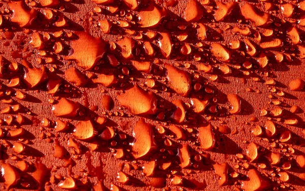 Gotas Agua Una Superficie Roja —  Fotos de Stock