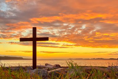 Karanlık Haç, çimenlik bir nehir kıyısında, ılık günbatımı gökyüzü.