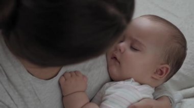 Tıp, sağlık, aile, masumiyet, pediatri, mutluluk, bebek konseptleri - Genç mutlu anneyi kapat 7 ay kucak kucak kucak kucak uyu ve çocuk odasında ninni söyle