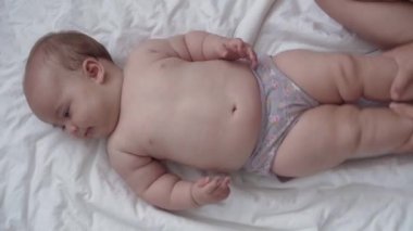 Tıp, sağlık, masumiyet, pediatri, bebek konseptleri - anne elleri yeni doğan çocuğuna bacak, ayak, parmak ve egzersiz, karın veya göğüs masajı yapar.