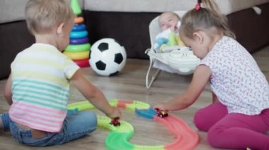 Çocukluk, oyunlar, terbiye ve gelişim konsepti. Yeni doğmuş bebekli annenin genel planı. Çocuklar, erkek ve kız kardeşler oyun odasında sihirli yollarla oynuyorlar. Kardeşler karantinada eğleniyor.