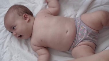 Tıp, sağlık, masumiyet, pediatri, bebek konseptleri - anne elleri yeni doğan çocuğuna bacak, ayak, parmak ve egzersiz, karın veya göğüs masajı yapar.