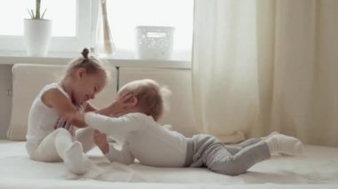 Aile, masumiyet, bebek kavramları iki gülümseyen çocuk kavga eder, oynaşırlar, yatakta dalga geçerler. Kardeşler küçük erkek ve kız kardeşler evde karantinada eğleniyor ve gülüyorlar..