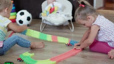 Çocukluk, oyunlar, terbiye ve gelişim konsepti. Yeni doğmuş bebekli annenin genel planı. Çocuklar, erkek ve kız kardeşler oyun odasında sihirli yollarla oynuyorlar. Kardeşler karantinada eğleniyor.