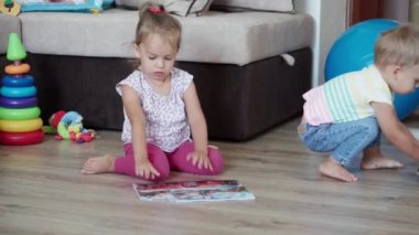 Çocukluk, oyunlar, yetiştirme ve geliştirme konsepti. Küçük çocukların genel planı. Erkek kardeş ve kız kardeş ile anne çocuk oyun odasında bulmaca çözer. Kardeşlerin karantinadaki evleri eğlencelidir.