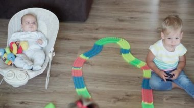 Çocukluk, oyunlar, yetiştirme ve geliştirme konsepti. Yeni doğan bebek ve çocukların en iyi bakış açısı. Erkek ve kız kardeş, çocuk oyun odasında sihirli yollarla oynuyor. Kardeşler karantinada eğleniyor.