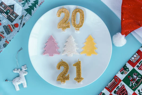 Weihnachten, Winter, Neujahr Konzept - Layout weiße Platte, auf der drei Weihnachtsbäume aus Wurstkäsebrot mit Weihnachtsmütze und goldenen Kerzen in Form von Zahlen 2021 Blauer Hintergrund — Stockfoto