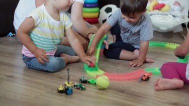 Çocukluk, oyunlar, terbiye ve gelişim konsepti. Yeni doğmuş bebekli annenin genel planı. Çocuklar, erkek ve kız kardeşler oyun odasında sihirli yollarla oynuyorlar. Kardeşler karantinada eğleniyor.