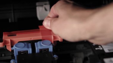 Video talimatları, teknoloji, basın, medya, ofis, kırtasiye konsepti - erkek ellerinin yeni mürekkep püskürtme yazıcıyı fırlatmaya hazırladığı yakın plan. Adım 1: turuncu ambalaj bandını ve koruyucu materyalleri kaldır