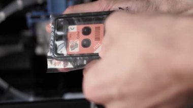 Video talimatları, teknoloji, basın, medya, ofis, kırtasiye konsepti - erkek ellerinin yeni mürekkep püskürtme yazıcıyı fırlatmaya hazırladığı yakın plan. Adım 2: koruyucu etiketi fişek doldurma boşluklarından kaldır