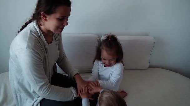 Jeugd, moederschap, broers en zussen concept - Zorgeloos speelse jonge moeder, twee kleine kinderen dochter, zoon veel plezier spelen op bed, gelukkig vrolijk familie klein kind meisje en jongen lachen kietelt, handen team — Stockvideo