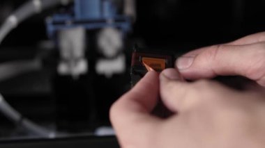 Video talimatları, teknoloji, basın, medya, ofis, kırtasiye konsepti - erkek ellerinin yeni mürekkep püskürtme yazıcıyı fırlatmaya hazırladığı yakın plan. Adım 3: parmak izi başlıklarından turuncu koruyucu bandı kaldır