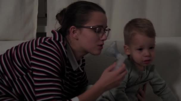 Orvoslás, öngyógyítás. Asztmás gyermekek maszkkal az arcukon lélegeznek az anyjukkal. Beteg gyerek légzőszervi légzés fertőzés hörghurut. pneumonia porlasztókészülék kezelése — Stock videók