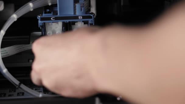 Video-Unterricht, Technik, Presse, Medien, Büro, Schreibwarenkonzept - Großaufnahme männlicher Hände bei der Vorbereitung eines neuen Tintenstrahldruckers für die Markteinführung. Schritt 4: Einbau von Farbe und schwarzer Patrone in den Verriegelungsdeckel — Stockvideo