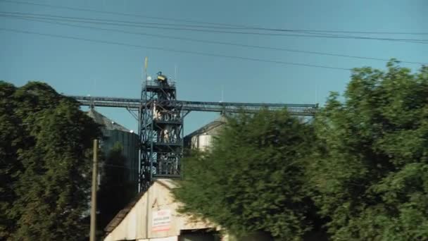 Trasporti, viaggi, strada, ferrovia, paesaggio, comnicazione, concetto di agricoltura - vista dalla finestra del treno di velocità sul paesaggio del campo naturale e silos di grano d'acciaio in tempo soleggiato sera d'estate — Video Stock