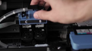 Video talimatları, teknoloji, basın, medya, ofis, kırtasiye konsepti - erkek ellerinin yeni mürekkep püskürtme yazıcıyı fırlatmaya hazırladığı yakın plan. Adım 5: Siyah fişek kapağını kapat ve aşağı it.