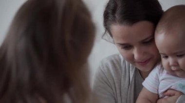 Çocukluk, annelik, kardeşlik kavramı - tasasız genç anne küçük çocuklarla çizgi film izler, yeni doğmuş bebek yatakta eğlenir, mutlu, büyük aile gülüşü gıdıklanır, öpüşür, sarılır.