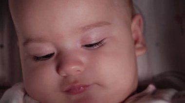 Bebek, çocukluk, duygu konsepti. Kahverengi gözlü, tombul, yeni doğmuş, uyanık, dişsiz bir bebeğin sevimli gülümseyen yüzüne yakın çekim. 7 aylık bebek kameraya bakıyor.